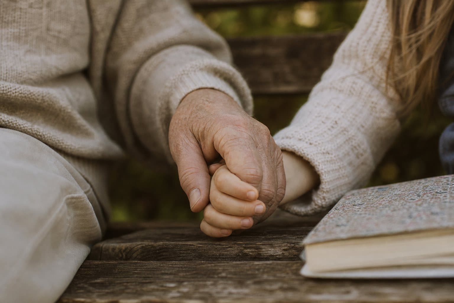 Drei Generationen halten einander die Hände
